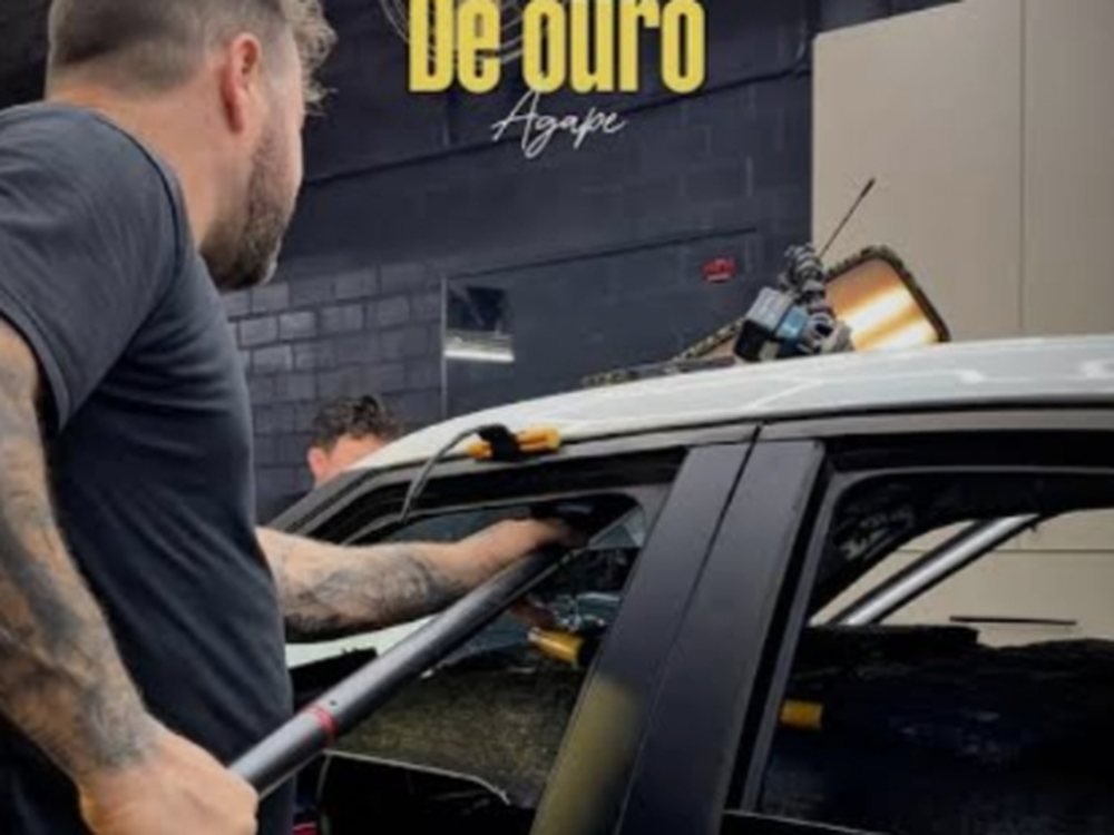 Profissional executando martelinho de ouro na porta de um carro prata